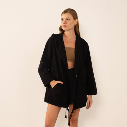 Girl wearing a black cotton jacket on a white background