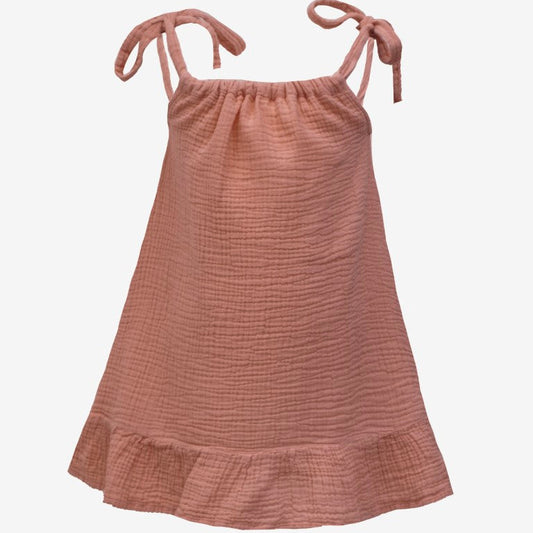 A dusty rose pink textured cotton gauze sleeveless dress with tie-shoulder straps and a ruffled hem, shown against a plain white background.