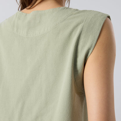 Light green sleeveless top worn by a person on a plain background