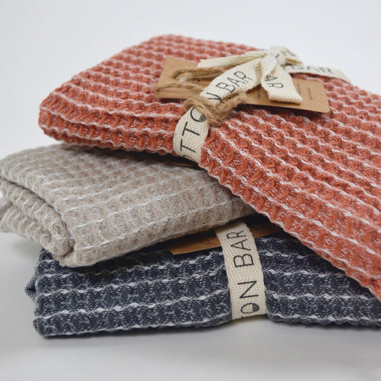Stack of textured towels with tags on a white background