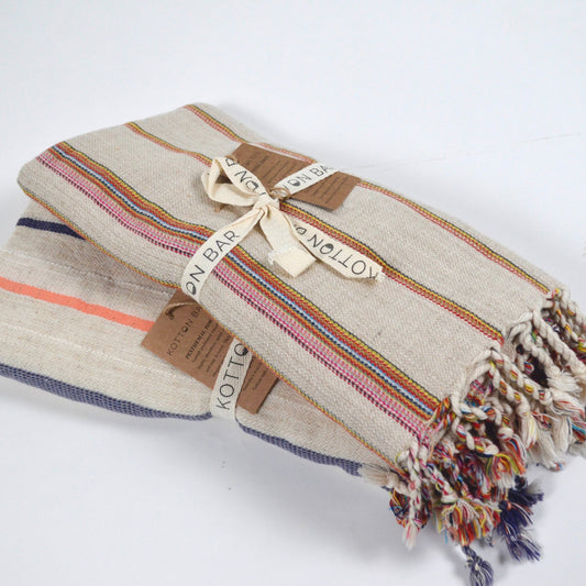 Textured blanket with colorful stripes and tassels on a white background