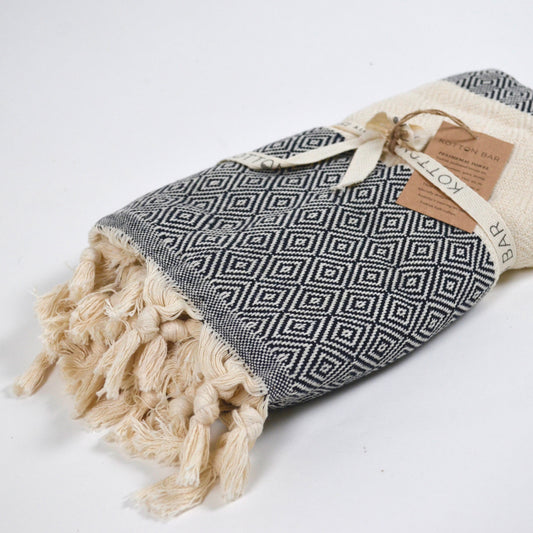 Patterned towel with tassels and a tag on a white background