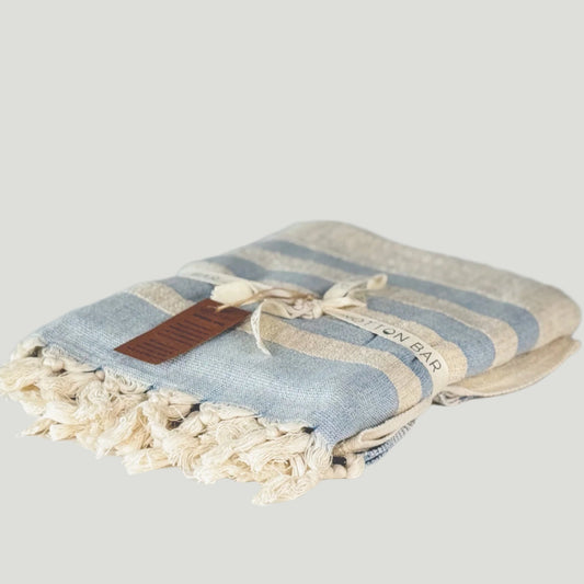 Striped towel with tassels on a light gray background