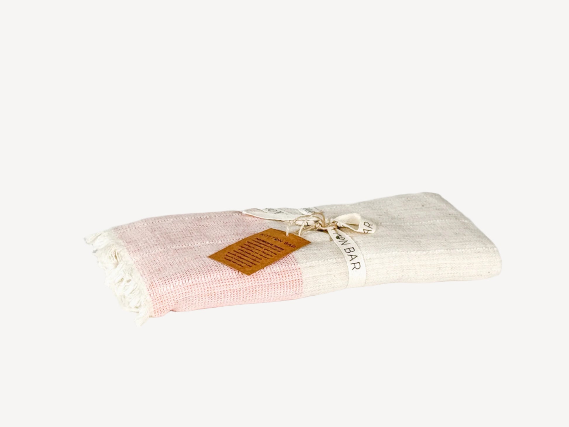 Folded pink and white towel with a brown label on a light gray background