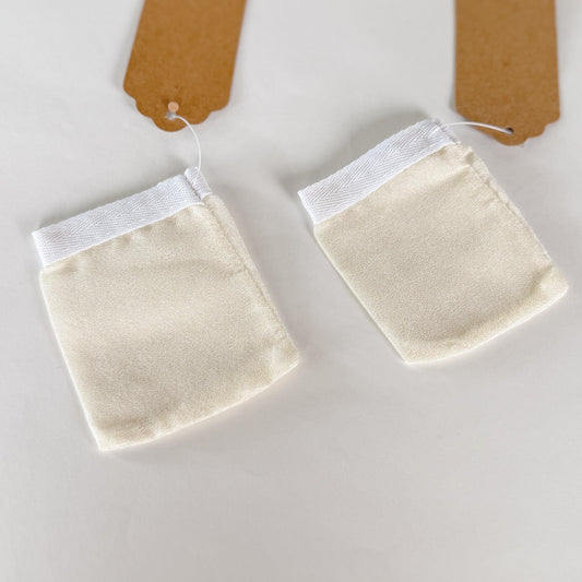 Two beige fabric pouches with white interiors on a light gray background.