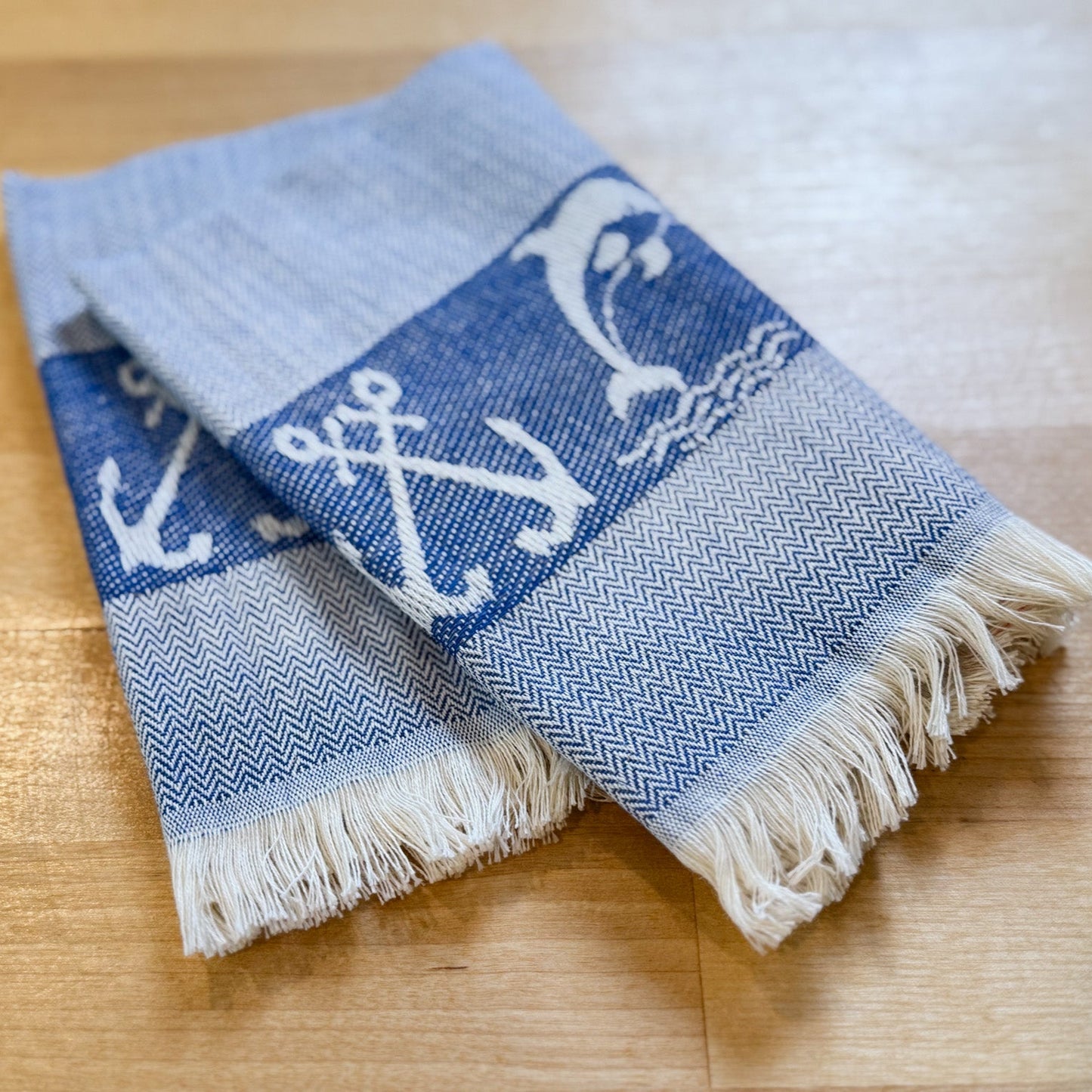 Folded towel with anchor pattern on a wooden surface