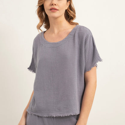 Woman wearing a lilac textured top and pants on a white background